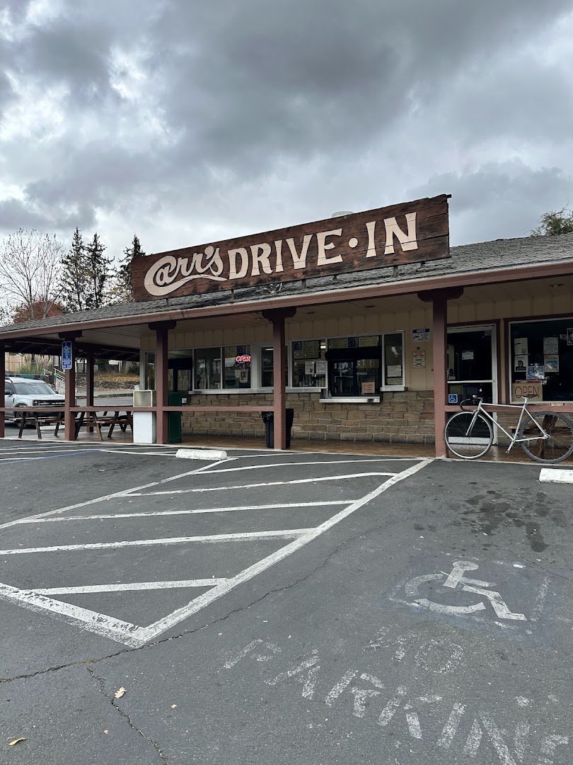 Classic drive-in exterior with parked cars nearby.