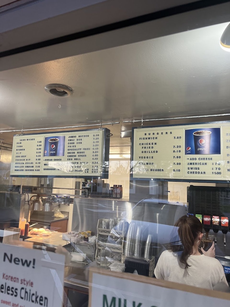 Menu board with burgers, shakes, and fries.